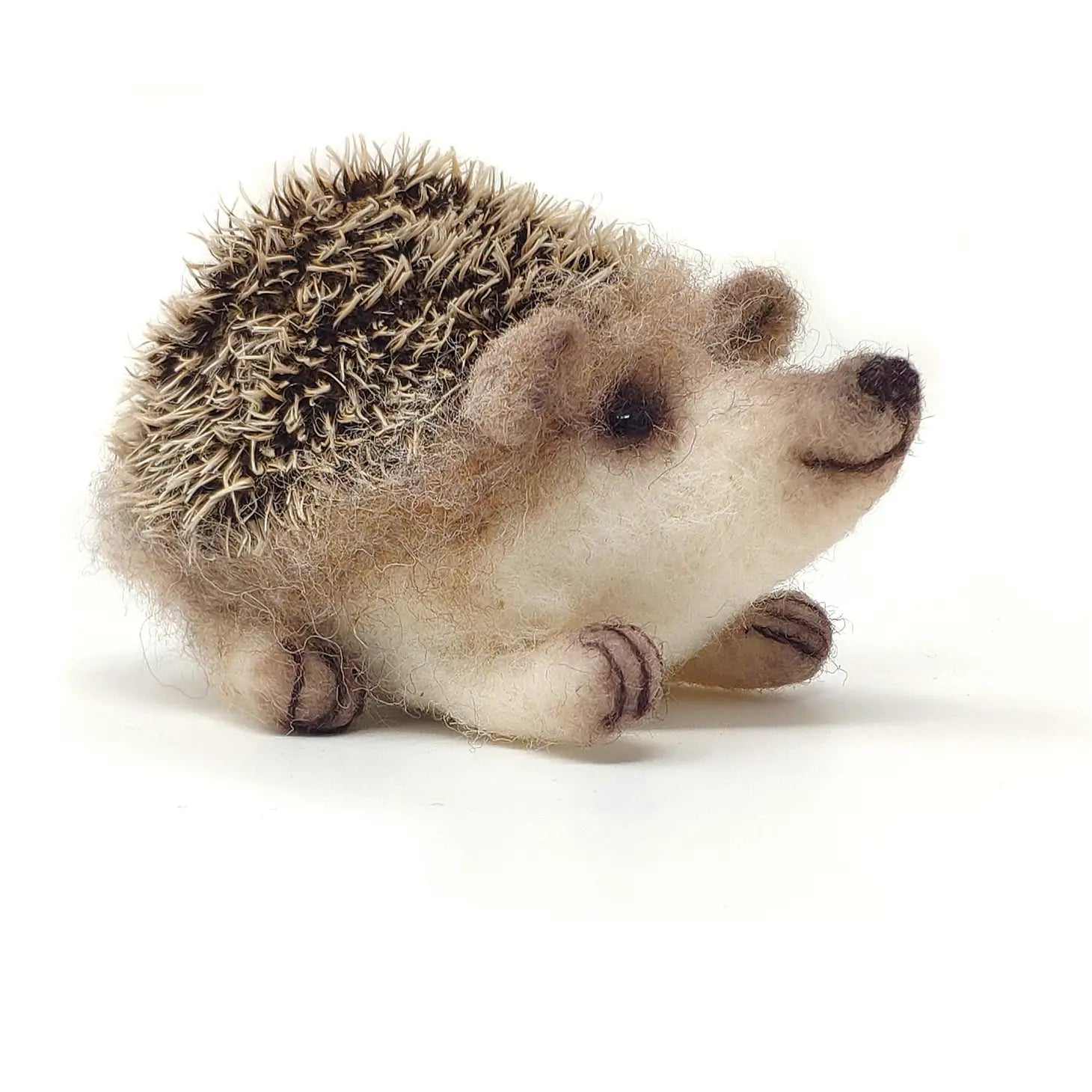 The Crafty Kit Company Baby Hedgehog, crafted from Corriedale wool and featuring detailed spines, tiny feet, and an adorable face, is displayed on a white background.
