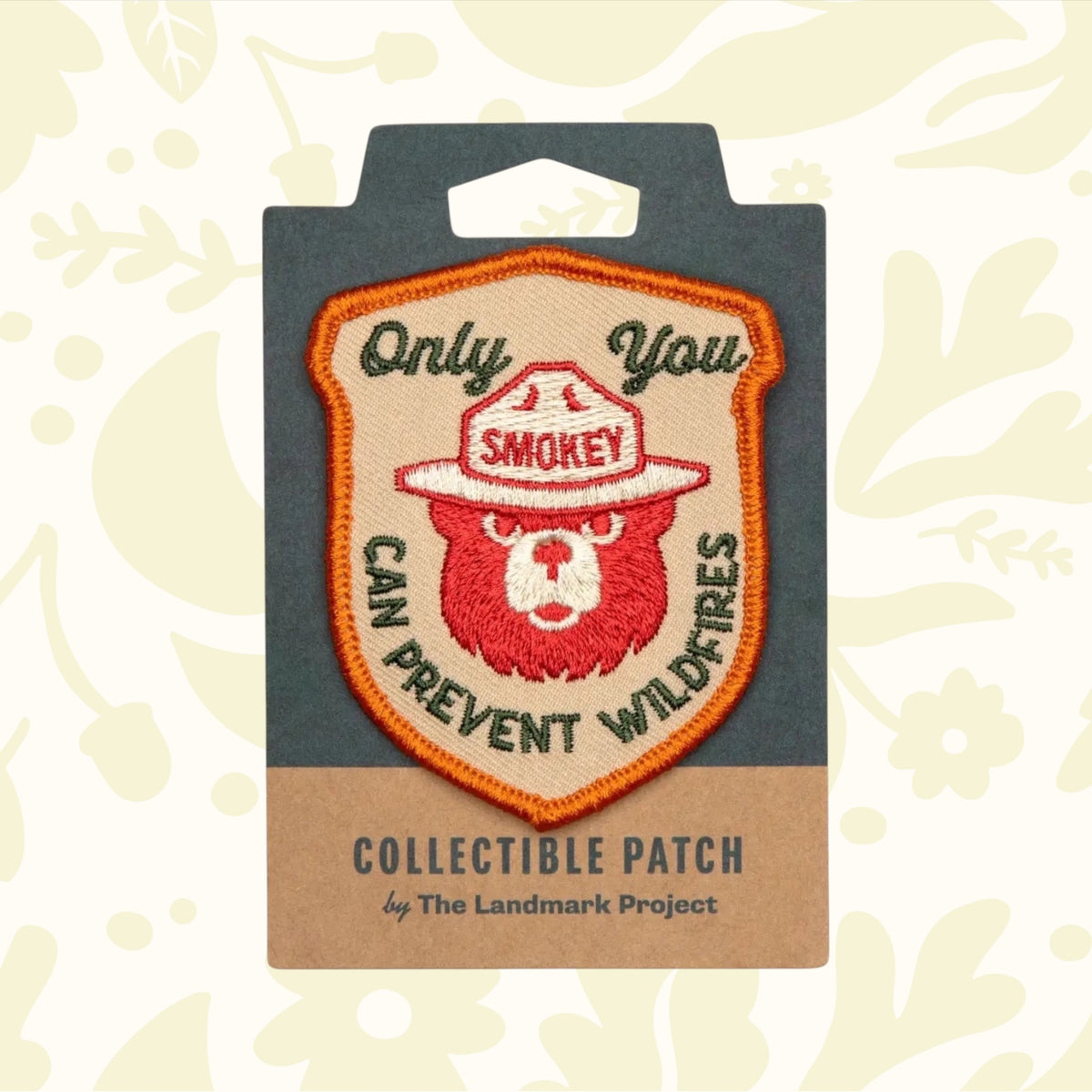 This licensed product, The Landmark Project Smokey Bear Patch - Only You Heritage, is an embroidered patch featuring Smokey Bear wearing a ranger hat and the text "Only You Can Prevent Wildfires." It is thoughtfully packaged by The Landmark Project.