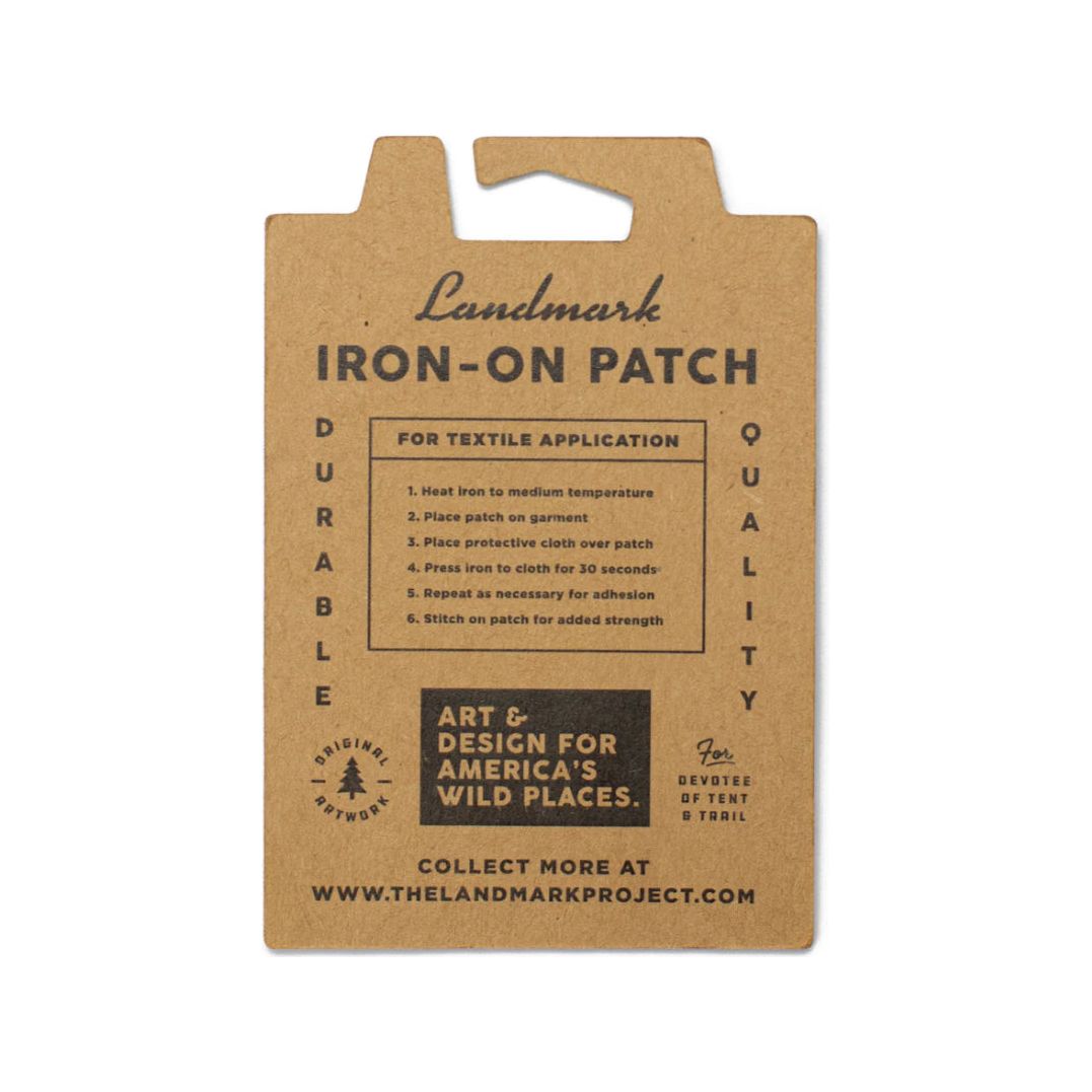 A brown card with instructions for using The Landmark Project Grand Canyon National Parks Patch, ideal for outdoor adventures. Text: "Durable Quality" and "Art & Design for America's Wild Places." Comes in sustainable packaging.
