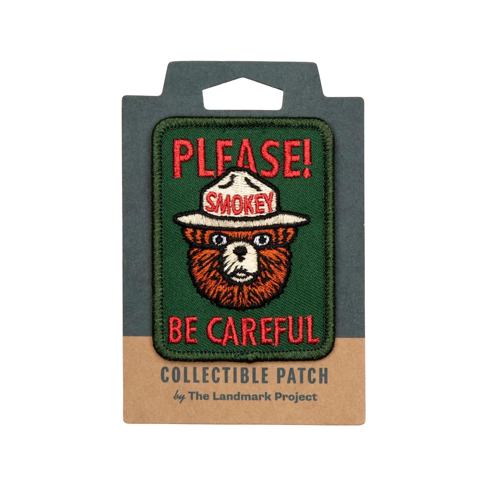 The official licensed "The Landmark Project Smokey Bear Patch - Please Becareful" from the USDA Forest Service features a collectible design of Smokey Bear with the text "PLEASE! BE CAREFUL." above and below him, supporting wildfire prevention education.
