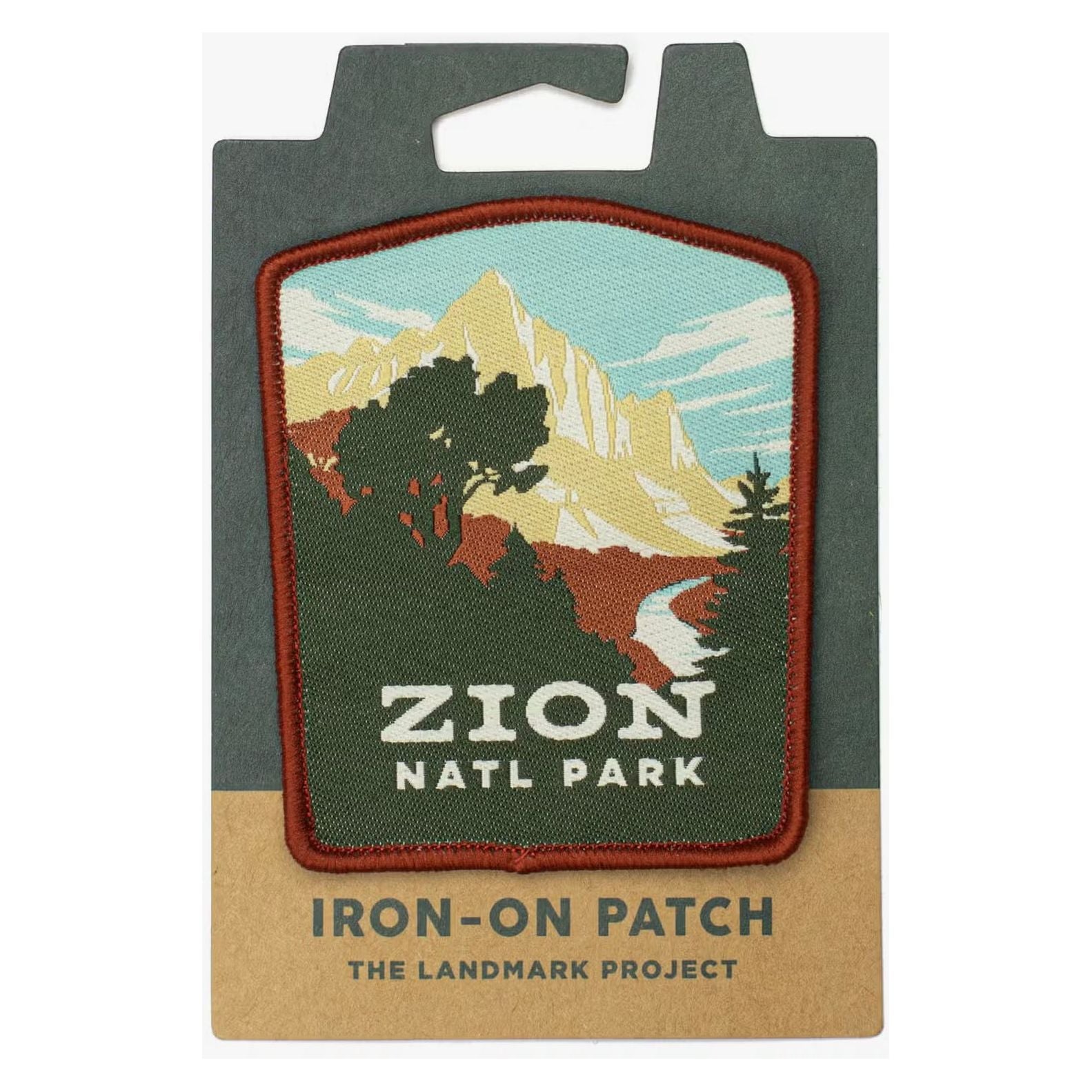Introducing The Landmark Project Zion National Parks Patch: a beautifully crafted iron-on patch featuring a scenic depiction of mountains, trees, and a river, perfect for outdoor adventures. This stunning patch is presented on sustainable packaging made from eco-friendly cardboard.