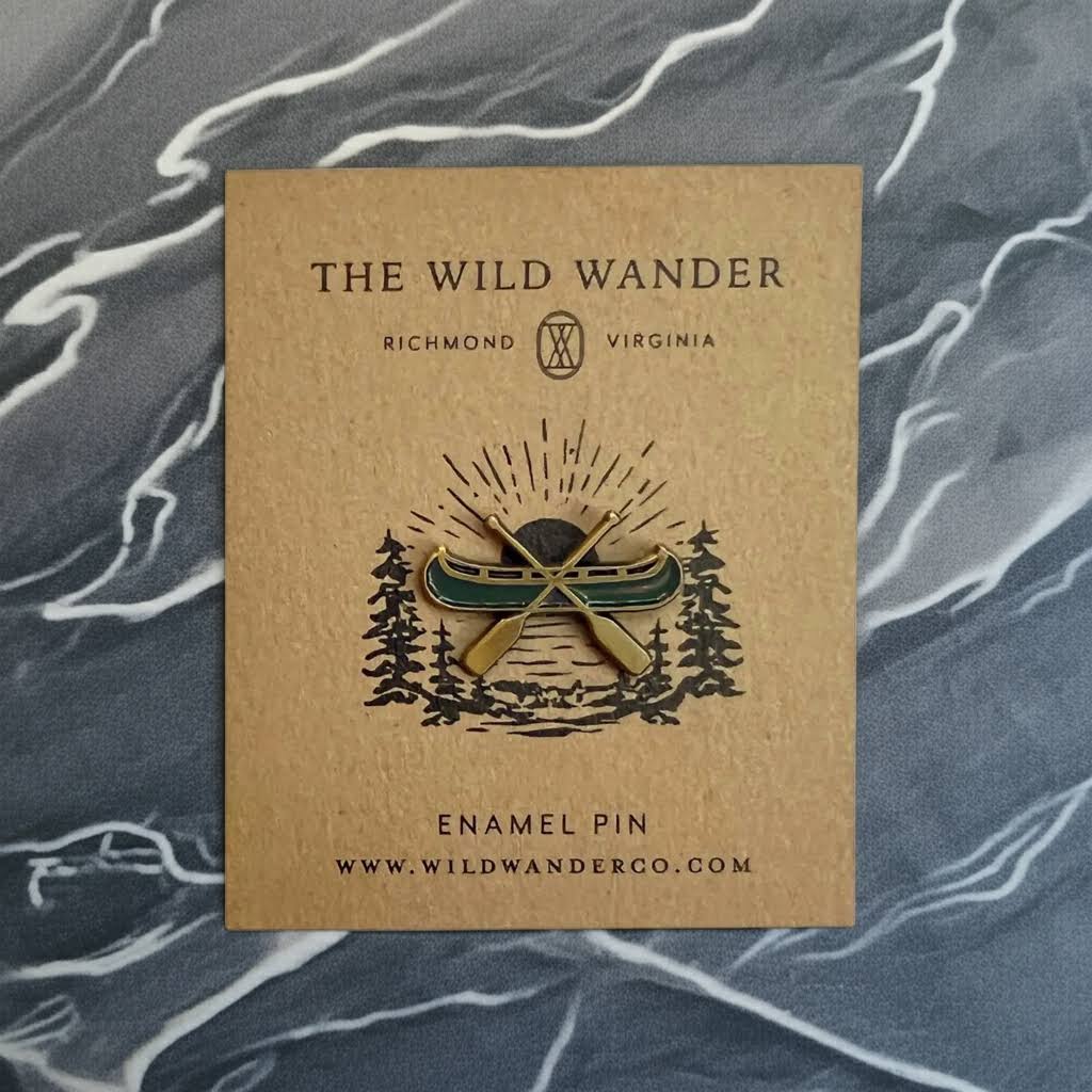 Forager Provisions LTD The Wild Wander canoe enamel pin in green and gold on a branded kraft paper backing card.
