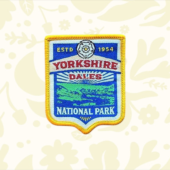 Yorkshire Dales National Park patch by The Adventure Patch Company on rustic scratched wood—collectible travel souvenir badge.