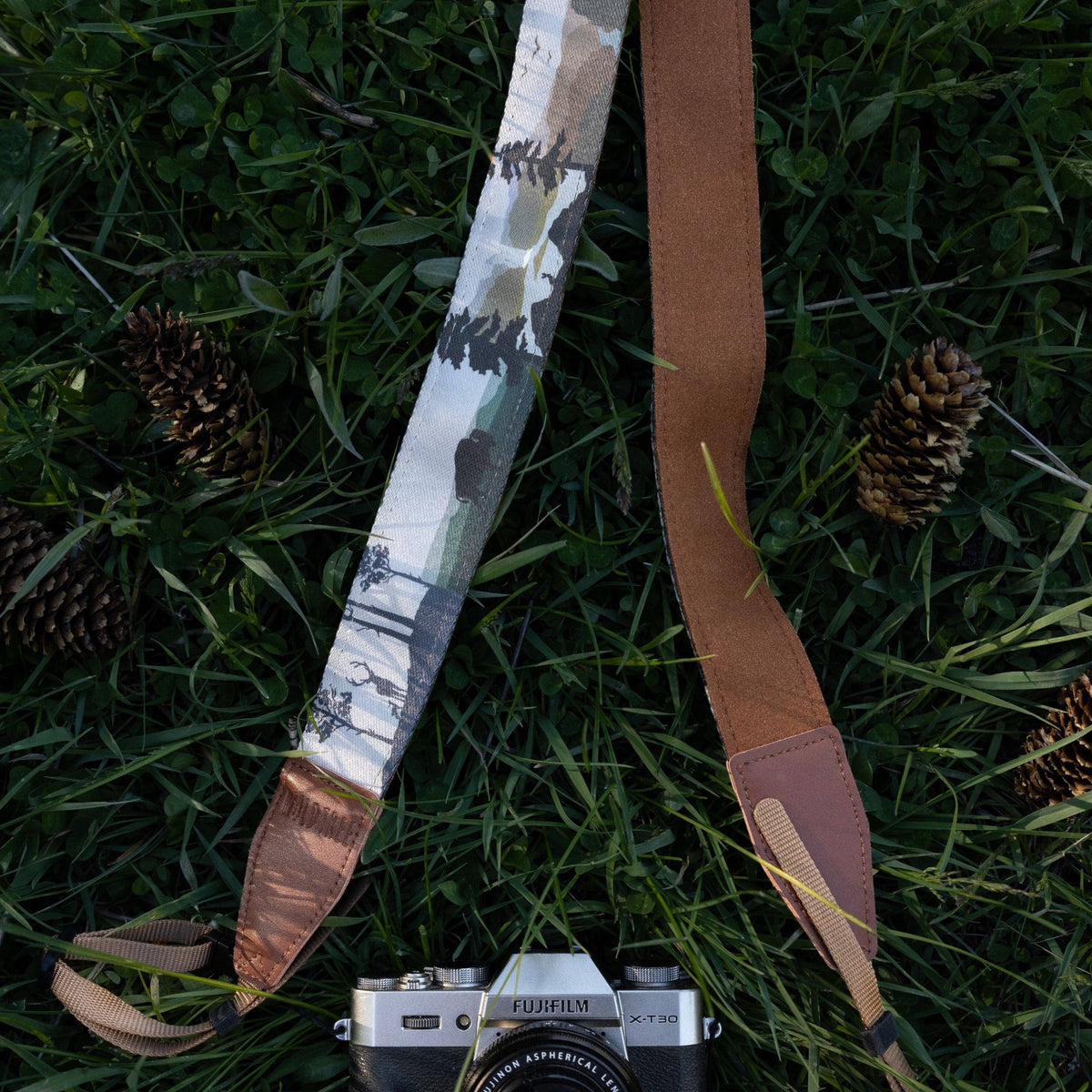 Forager Provisions LTD Wildtree Wildlife Wander camera strap with wilderness print and brown faux suede backing on grass