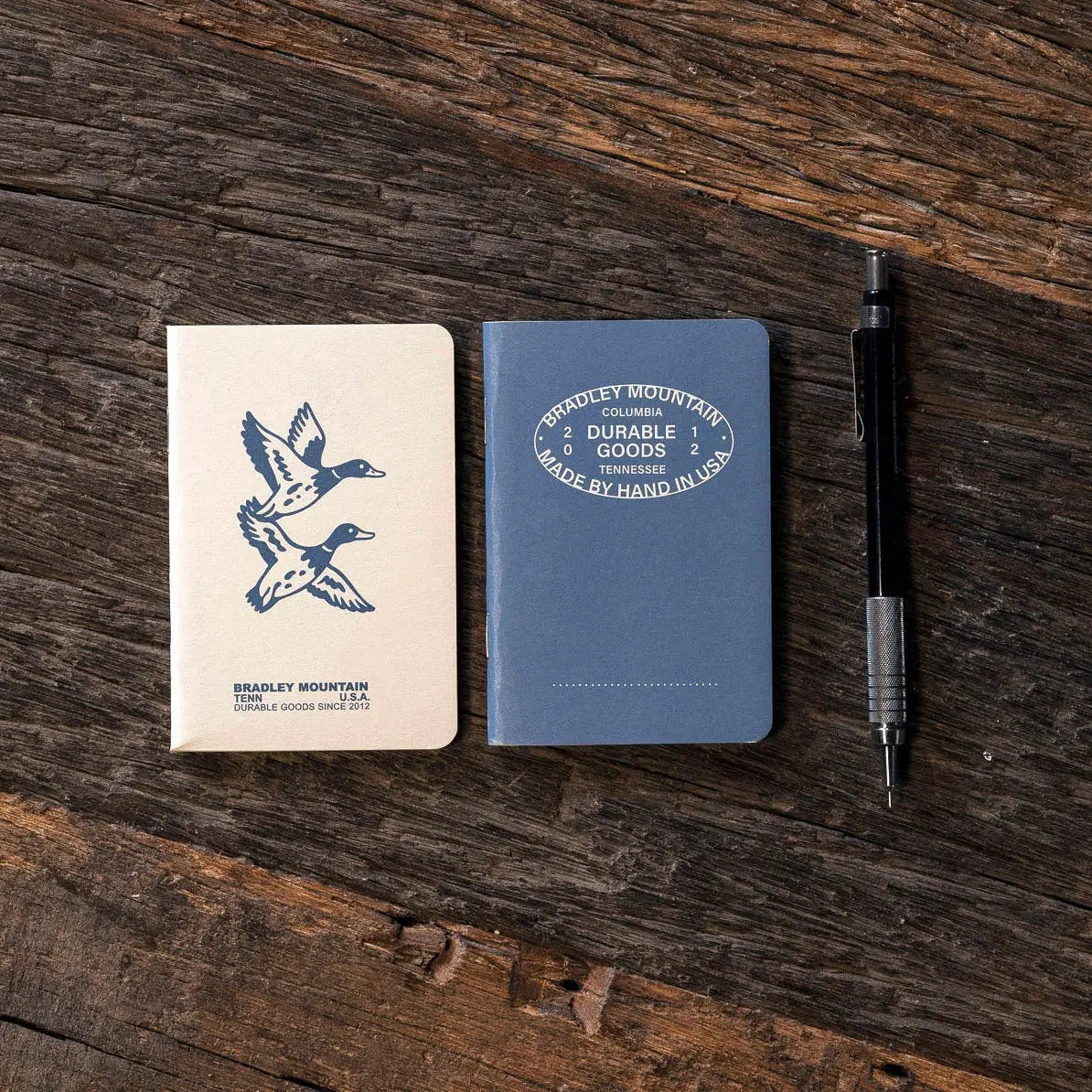 Forager Provisions LTD Bradley Mountain pocket journals in blue and cream with duck illustration on rustic wood table