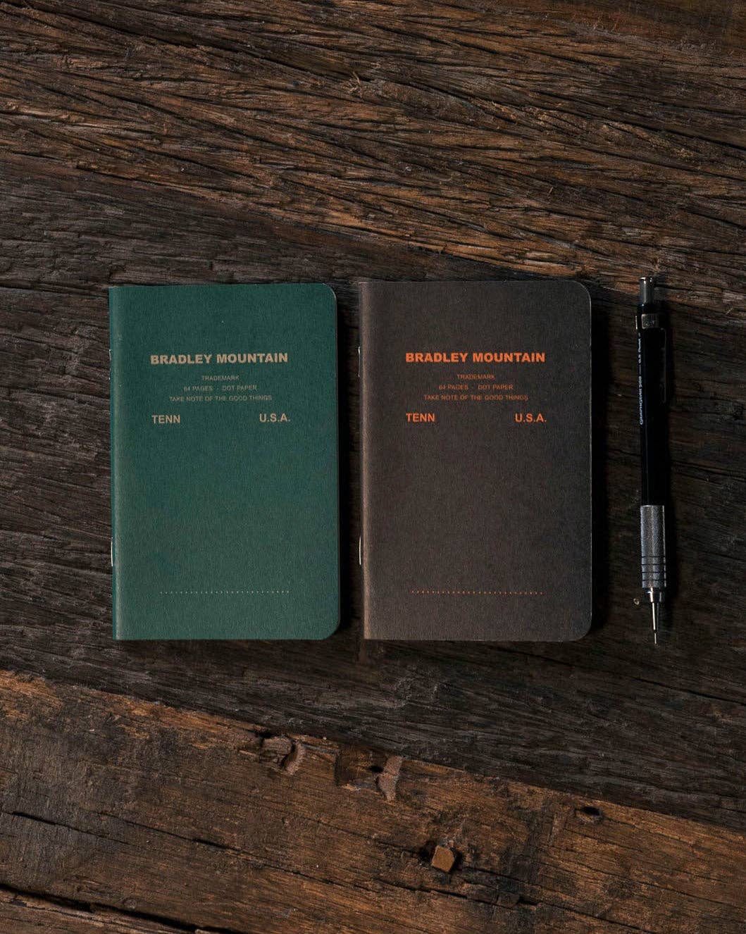 Forager Provisions LTD Bradley Mountain 2-pack pocket journals in green and brown with dot grid pages on wood surface.