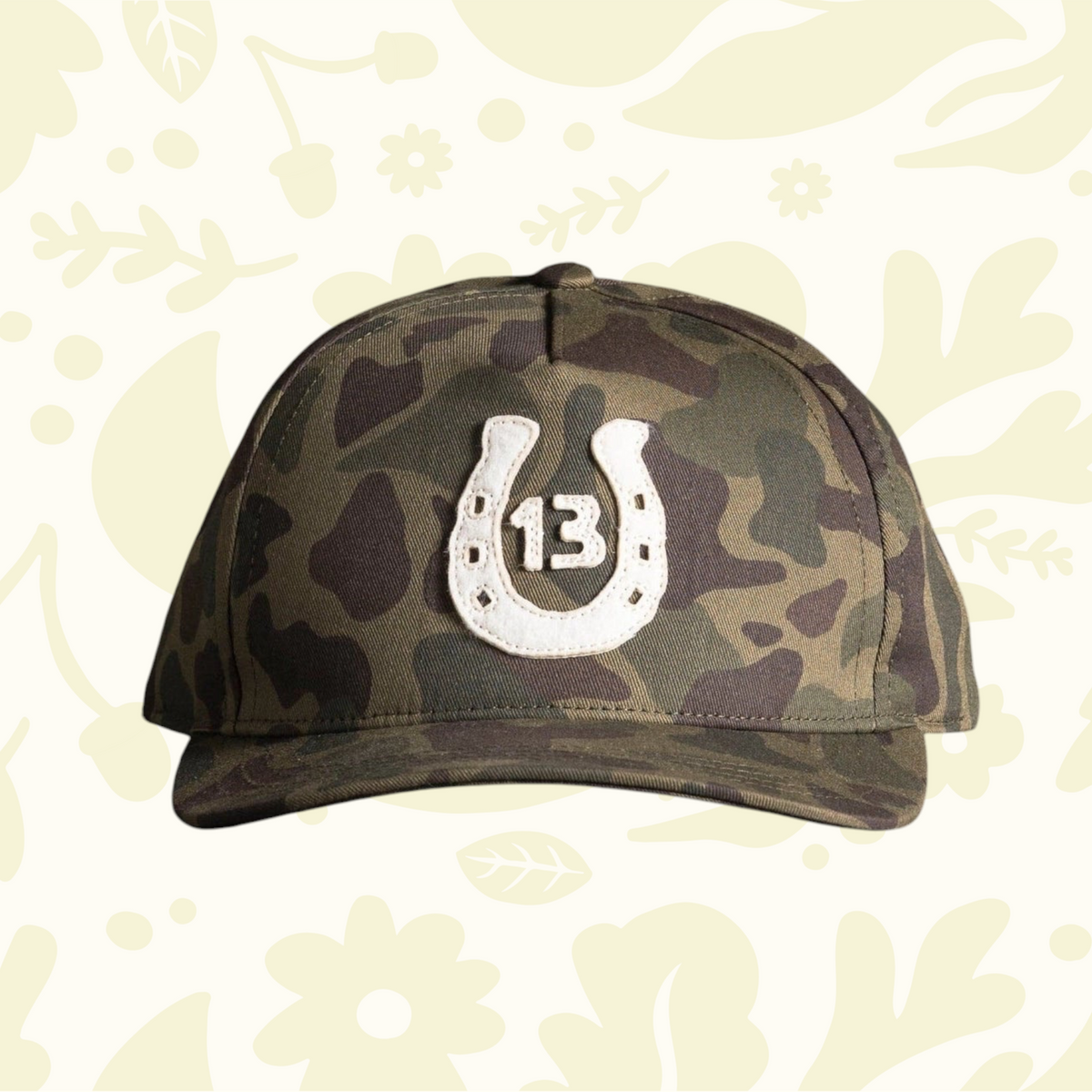Forager Provisions LTD Bradley Mountain woodland camo cotton twill cap with a white horseshoe 13 anniversary patch.