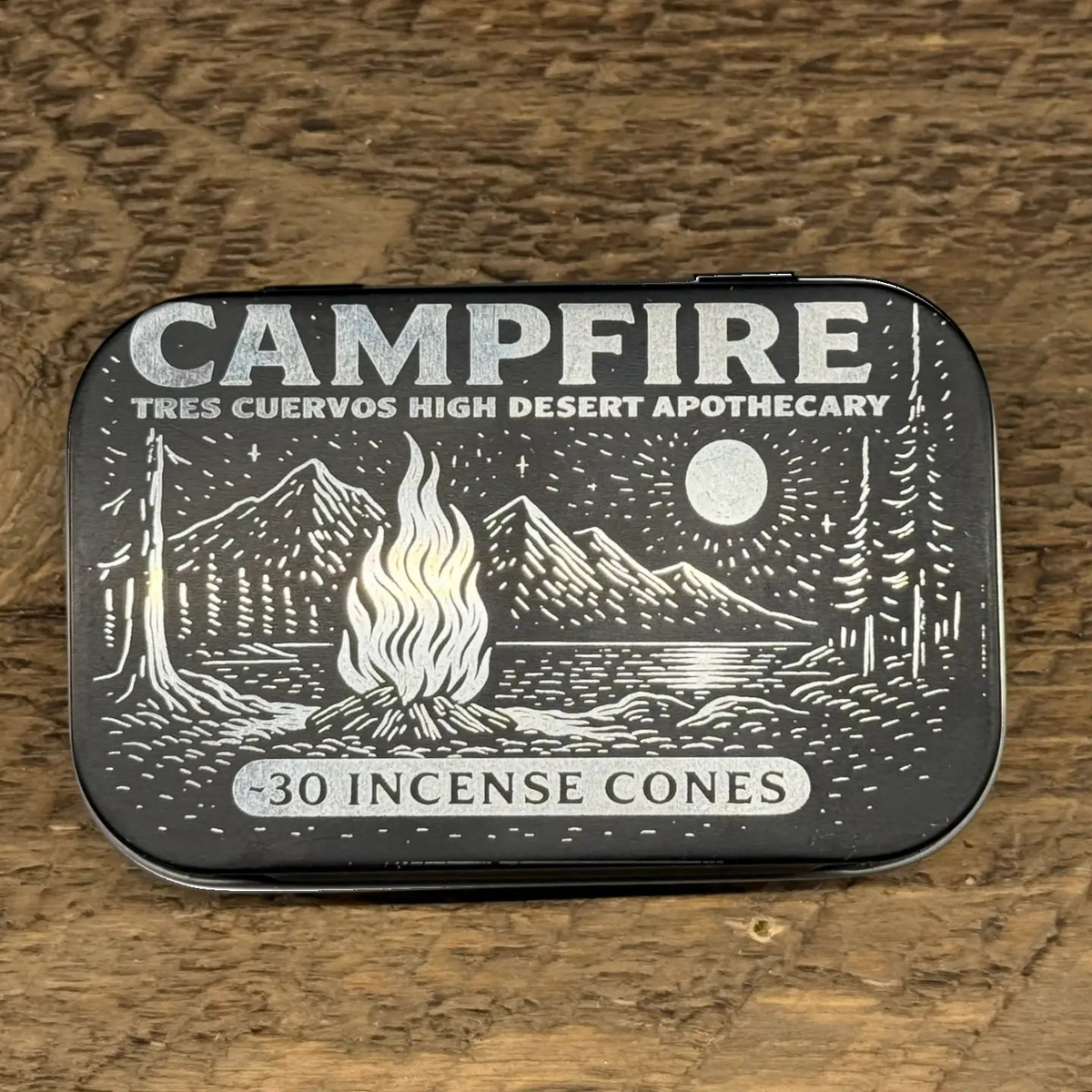 Forager Provisions LTD Tres Cuervos Campfire charcoal incense cones in a black illustrated metal tin on wood surface