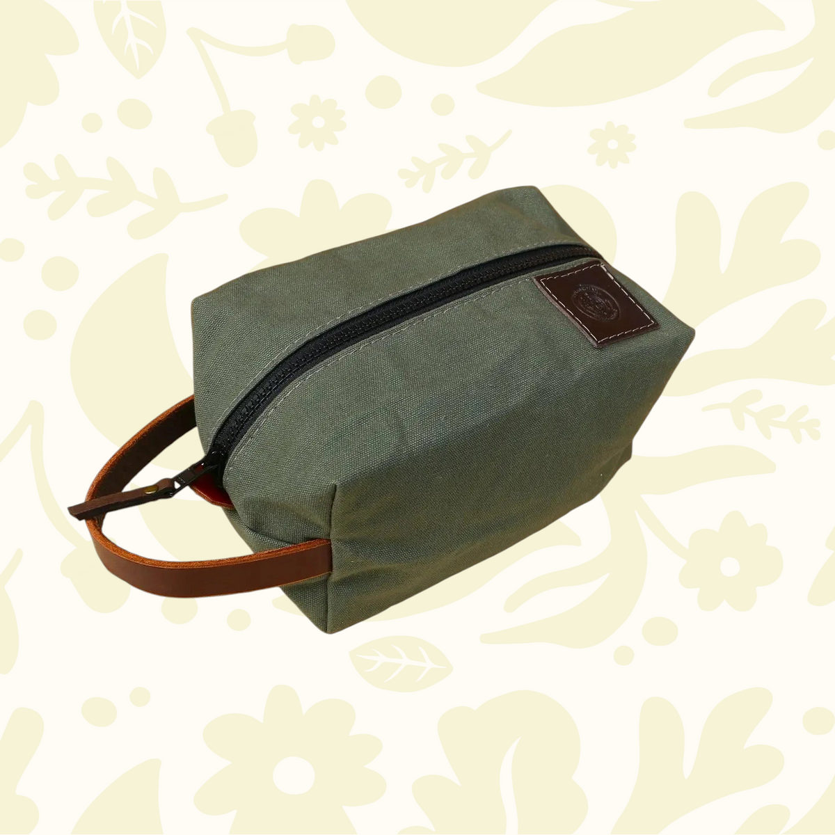 Forager Provisions LTD Journeyman Handcraft green cotton canvas toiletry bag with a brown leather handle and YKK zipper.