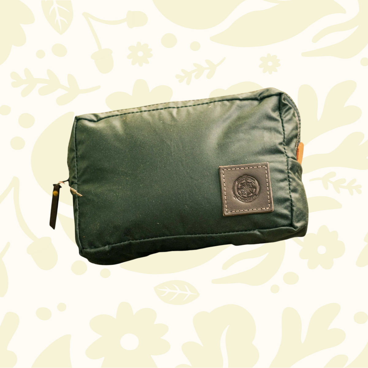 Forager Provisions LTD Journeyman Handcraft green waxed canvas expedition pouch resting on a mossy forest log