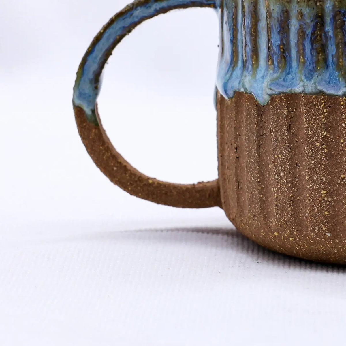 Forager Provisions LTD Ribera Bluvio Arte handmade stoneware mug with textured brown clay and blue drip glaze finish.