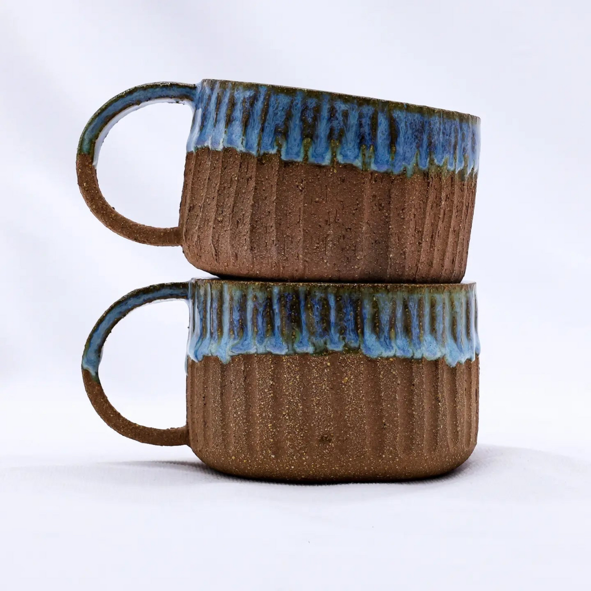 Forager Provisions LTD Ribera Bluvio Arte handmade stoneware mugs with textured brown clay and blue drip glaze.