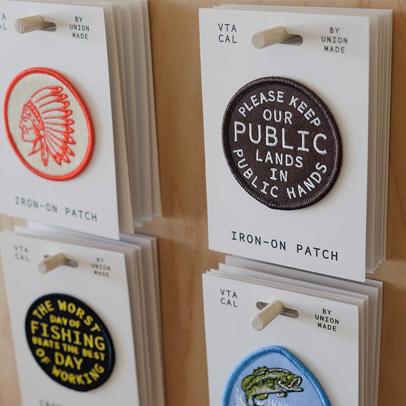 Forager Provisions LTD Hooked on Fishing iron-on patch displayed on a retail card with other outdoor themed patches.