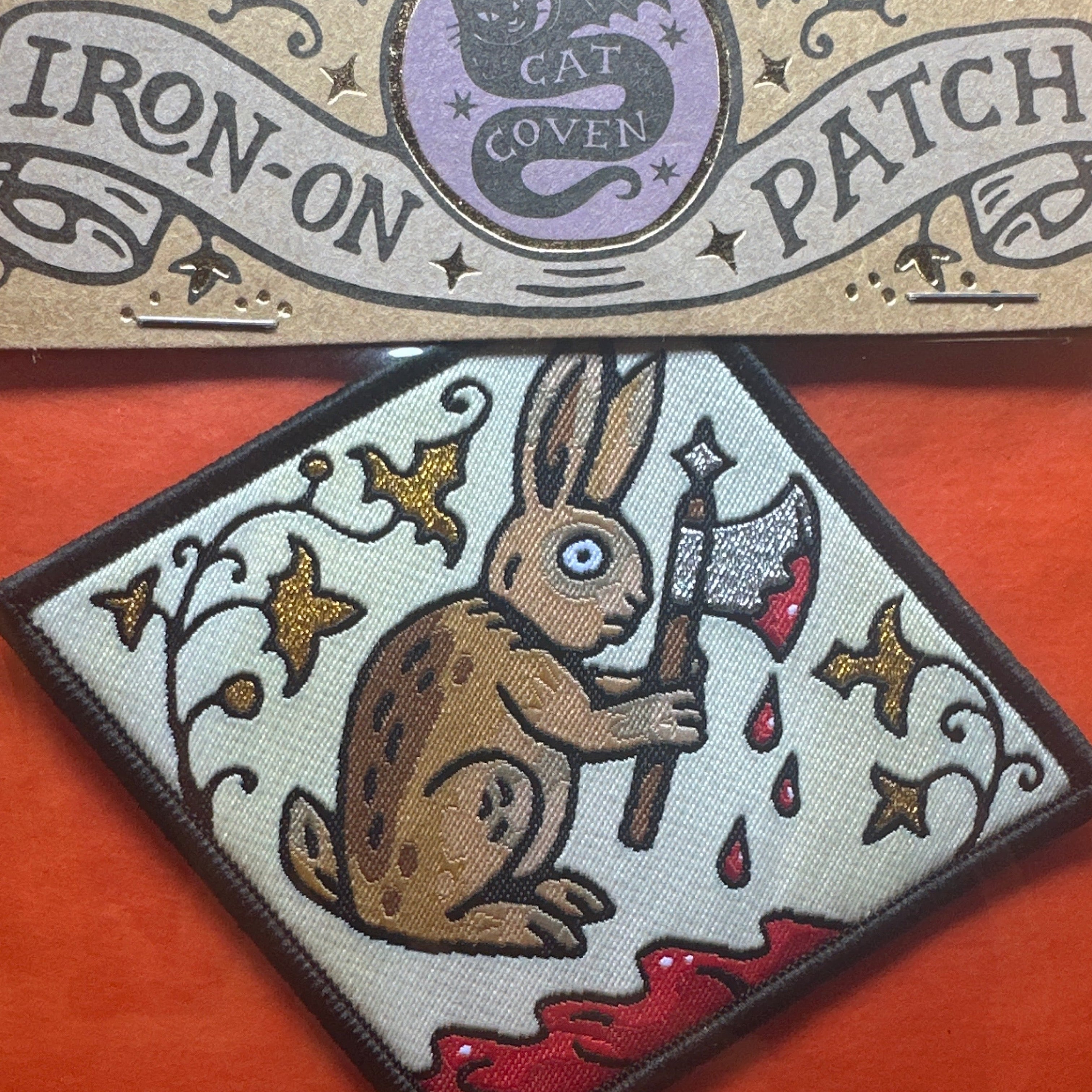 Forager Provisions LTD Cat Coven woven patch featuring a medieval rabbit holding an axe on a diamond-shaped background