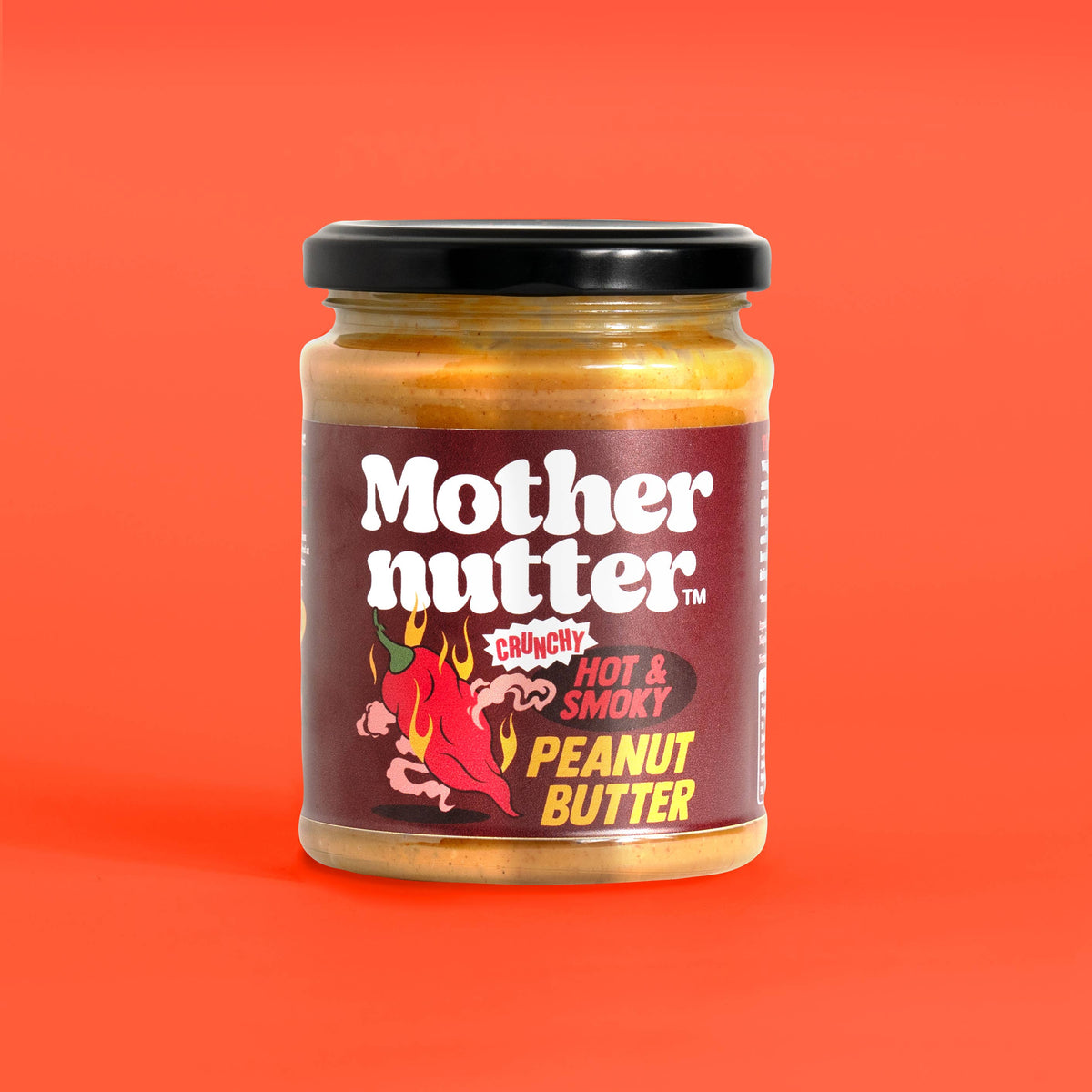 Forager Provisions LTD Mothernutter crunchy hot and smoky peanut butter in a glass jar against a bright orange background