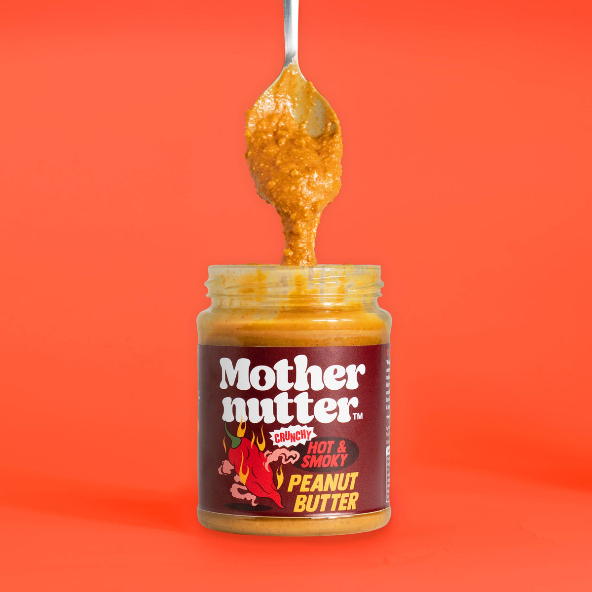 Forager Provisions LTD Mothernutter crunchy hot and smoky peanut butter in a glass jar with a spoonful being lifted.