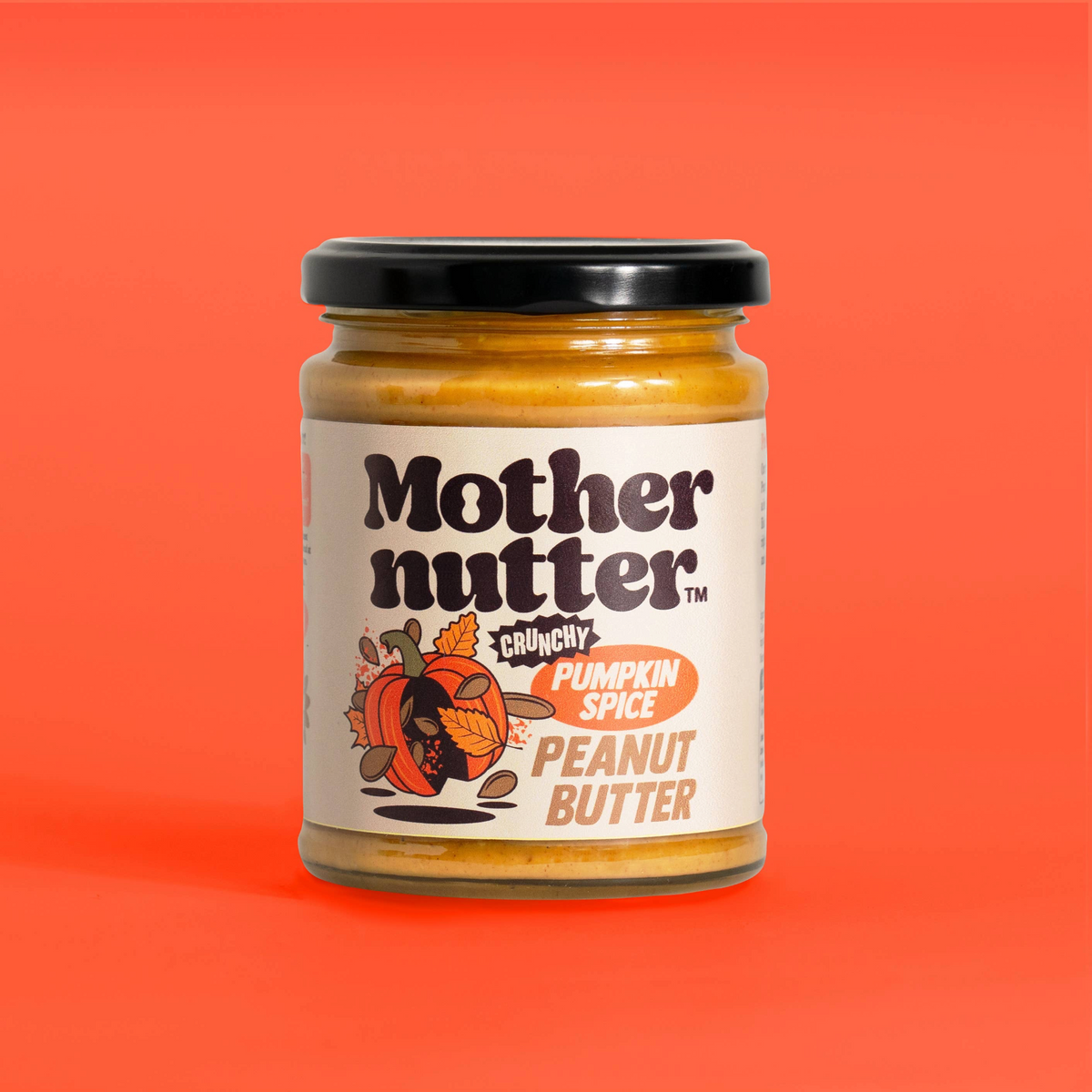Forager Provisions LTD Mothernutter crunchy pumpkin spice peanut butter in a glass jar against a bright orange background