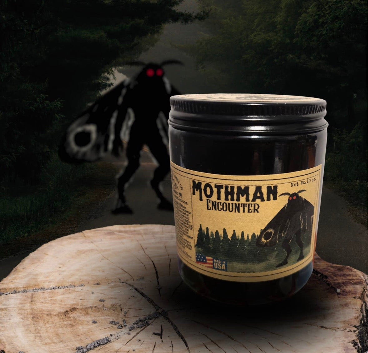 Forager Provisions LTD Mothman Encounter candle in a black jar with vintage-style label on a rustic wood slice.