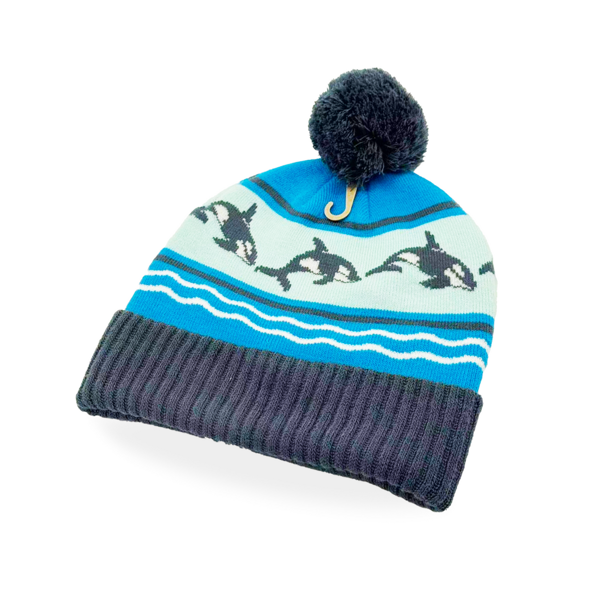 Forager Provisions LTD knit beanie in blue with a jumping orca whale pattern, wave stripes, and a dark grey pom-pom.