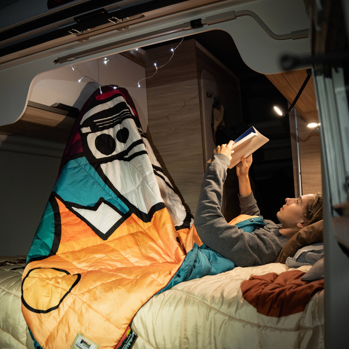 Forager Provisions LTD Seven Peaks all-terrain van life comforter with colourful graphic print used in a campervan