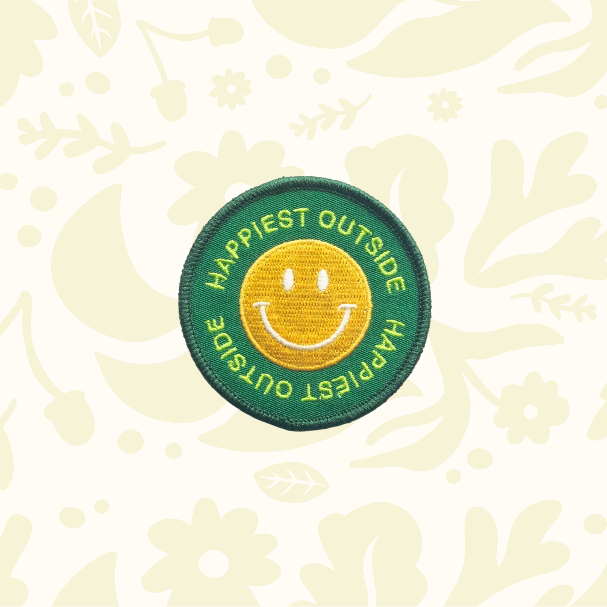 Forager Provisions LTD round embroidered iron-on patch with a yellow smiley face on a green background