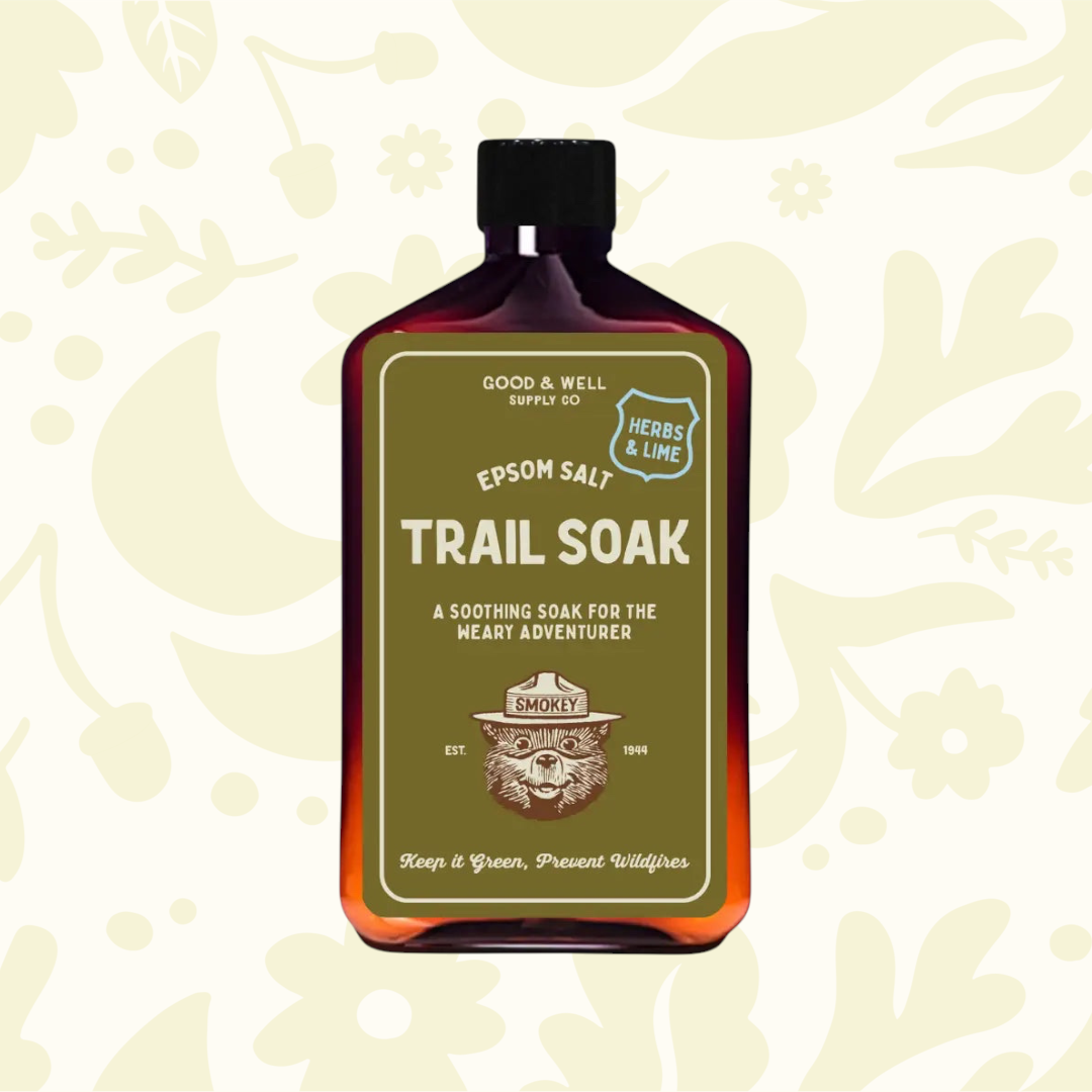 Forager Provisions LTD Good & Well Supply Co Smokey Bear Epsom Salt Trail Soak in an amber bottle with herbs and lime.