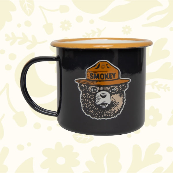 Forager Provisions LTD navy enamel mug featuring a Smokey Bear graphic with a tan rim, perfect for outdoor camping.