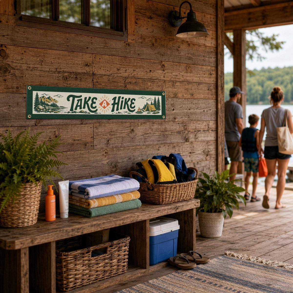 Forager Provisions LTD Benoit's Design Co. Take A Hike felt banner hanging on a rustic wooden cabin porch wall.