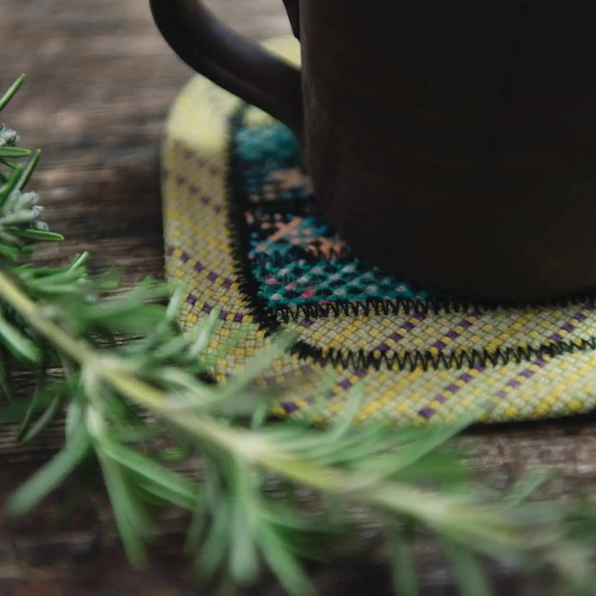 Forager Provisions LTD Scavenger upcycled climbing rope coaster in Earth tones with a mug on a rustic wooden surface