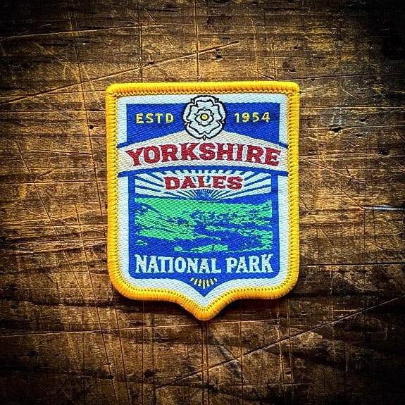 Forager Provisions LTD embroidered Yorkshire Dales National Park patch with yellow border on a rustic wooden surface.