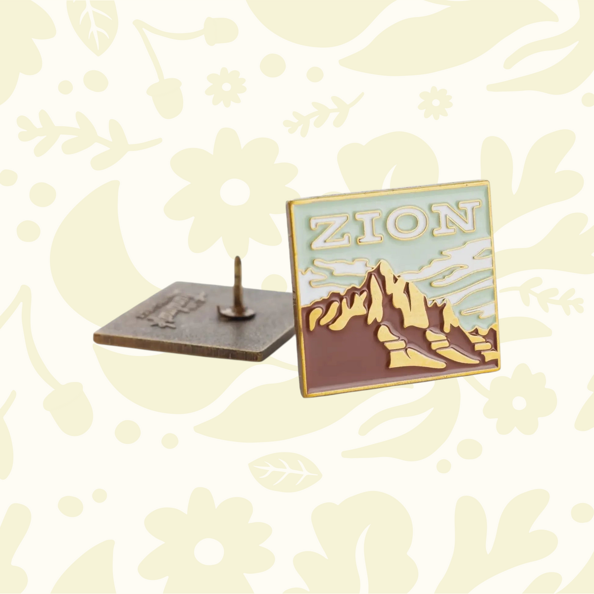Forager Provisions LTD Zion enamel pin featuring a square landscape design of mountains in a cream and brown palette.
