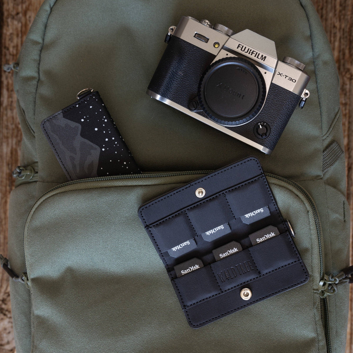 Forager Provisions LTD Wildtree Midnight Mountain card holder with SD cards and a Fujifilm camera on a green backpack