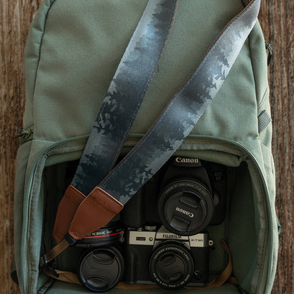 Forager Provisions LTD Wildtree Foggy Forest camera strap with mountain print and brown faux suede inside a green bag