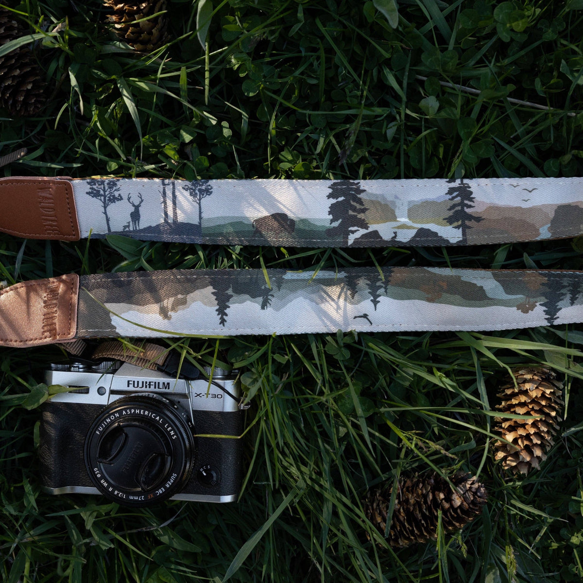 Forager Provisions LTD Wildtree Wildlife Wander camera strap with wilderness print and brown faux suede on grass