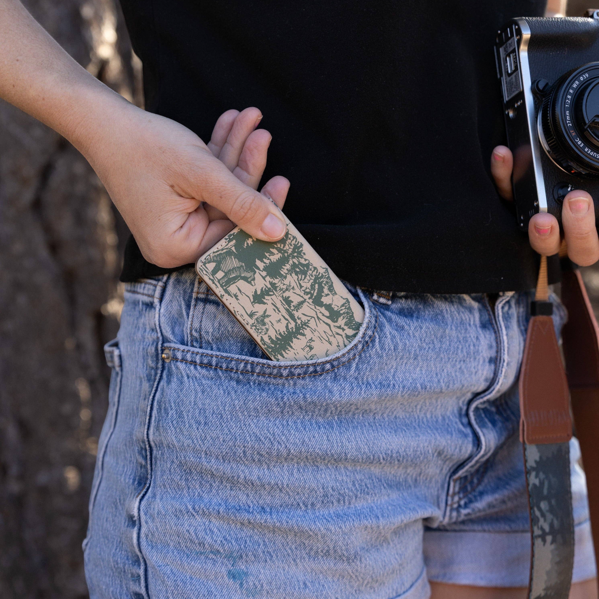 Forager Provisions LTD Wildtree Woodland Landscape card holder being placed into a denim shorts pocket by a photographer