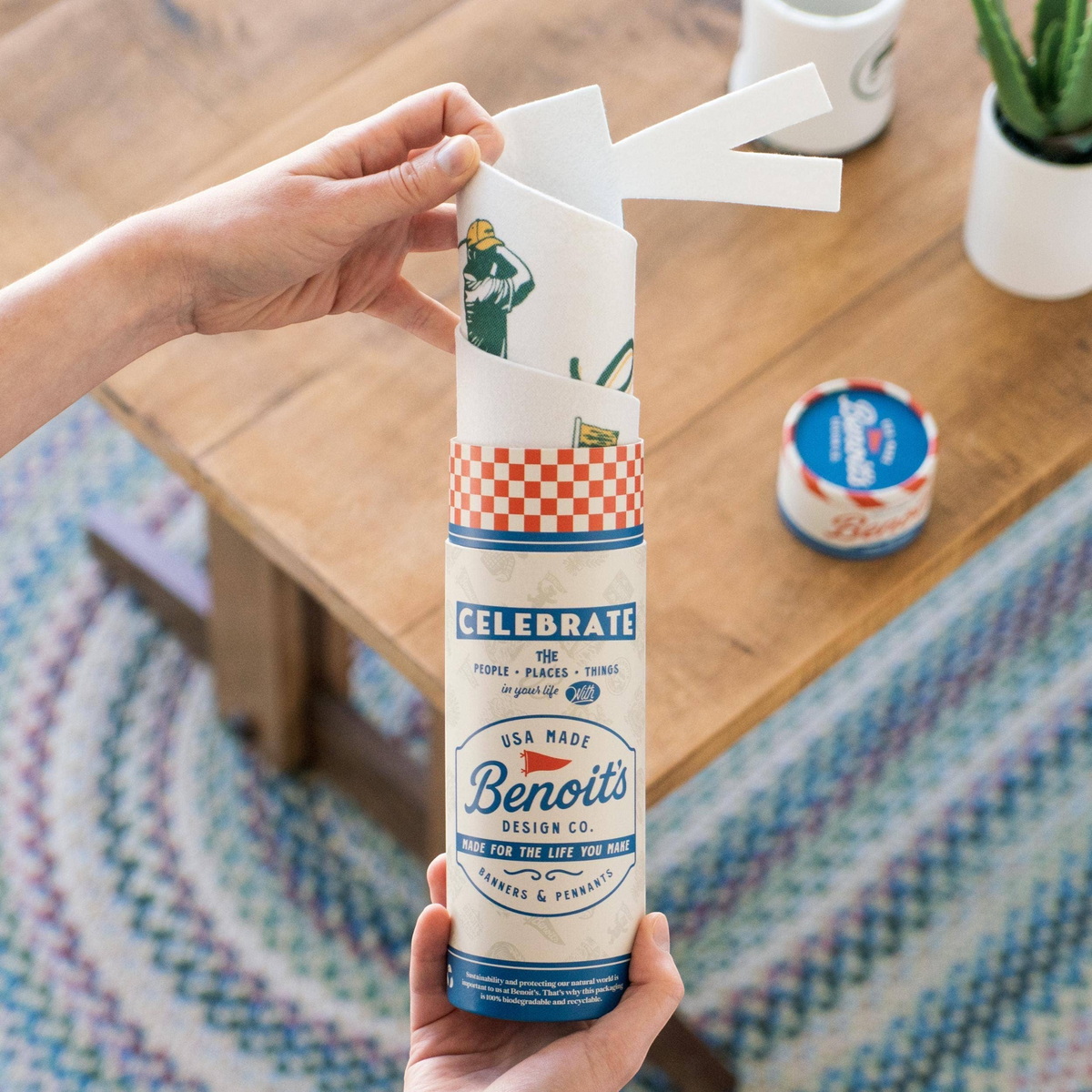 Forager Provisions LTD Benoit’s Supply Co. felt pennant being unrolled from its branded cardboard packaging tube.
