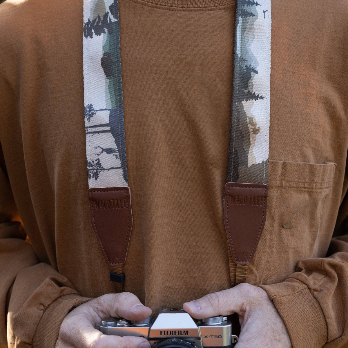 Forager Provisions LTD Wildtree Wildlife Wander camera strap with wilderness print, brown faux suede, and leather ends.