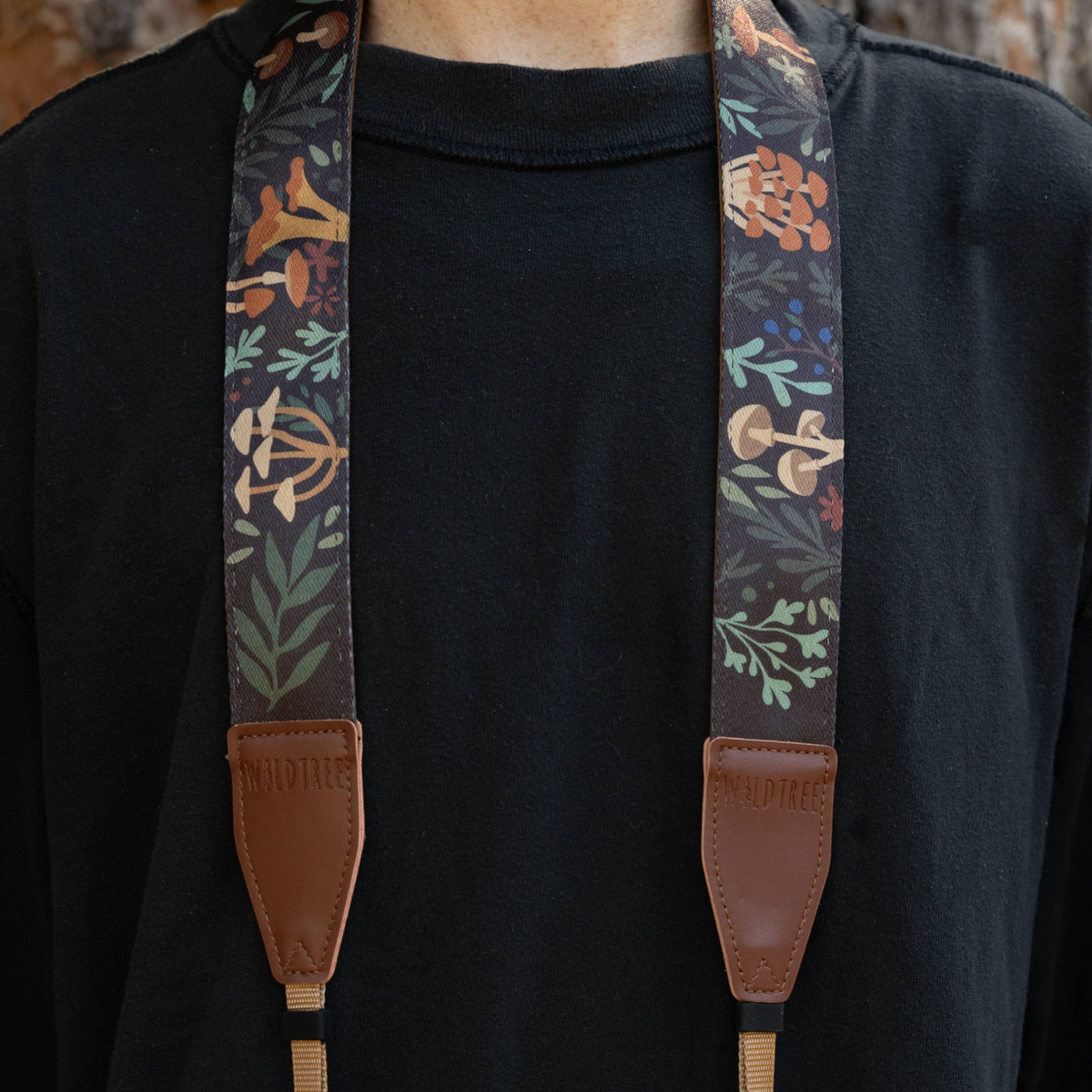 Forager Provisions LTD Wildtree Forest Foliage camera strap with mushroom and plant print on a person wearing black