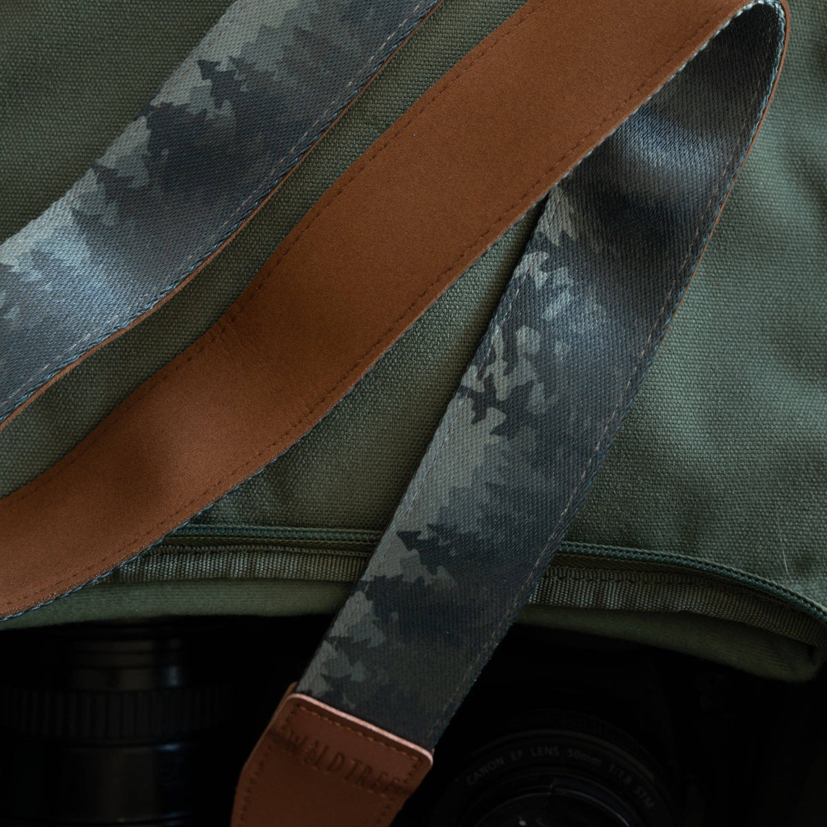Forager Provisions LTD Wildtree Foggy Forest camera strap with mountain print and brown faux suede backing on a bag