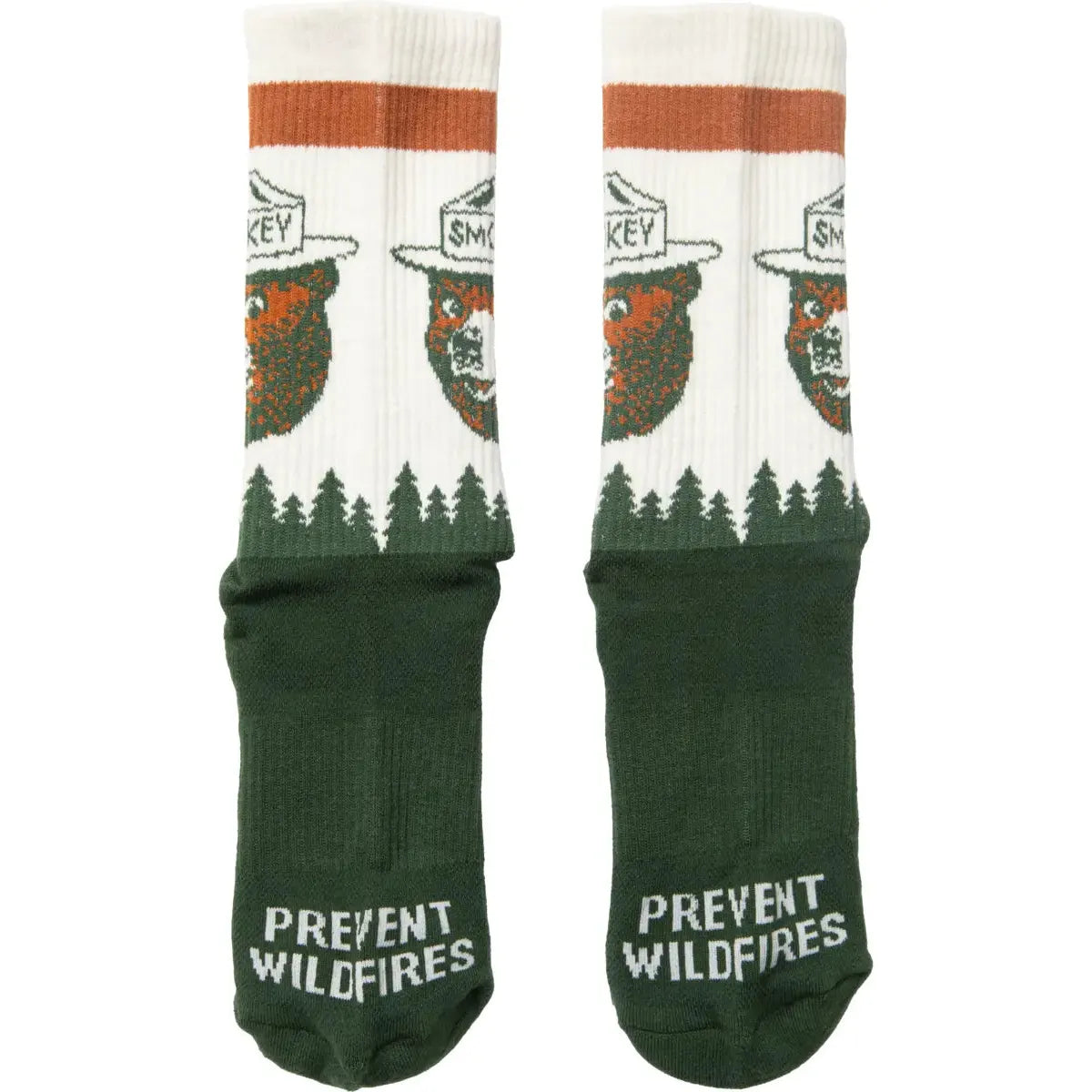 Close-up of The Landmark Project Smokey Bear Socks, crafted from green and white organic cotton, showcasing Smokey Bear in a ranger hat. The soles of the socks feature the phrase "Prevent Wildfires" alongside Smokey's logo.