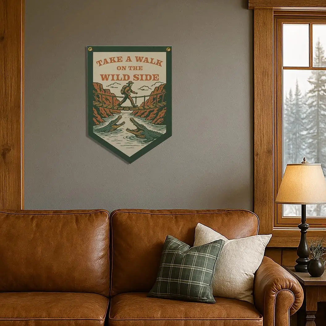 Cozy living room with brown couch, plaid pillows, and "Take A Walk On The Wild Side" felt banner for stylish home decor.