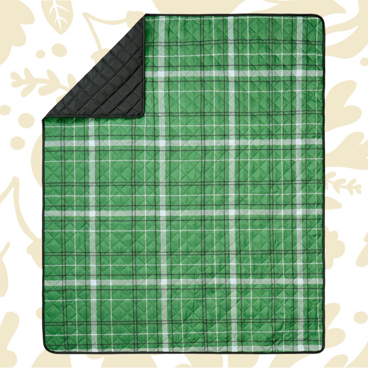 Shop the Peking Camp Wandawega picnic blanket with black lining, displayed on a beige leaf-patterned surface for outdoor use.