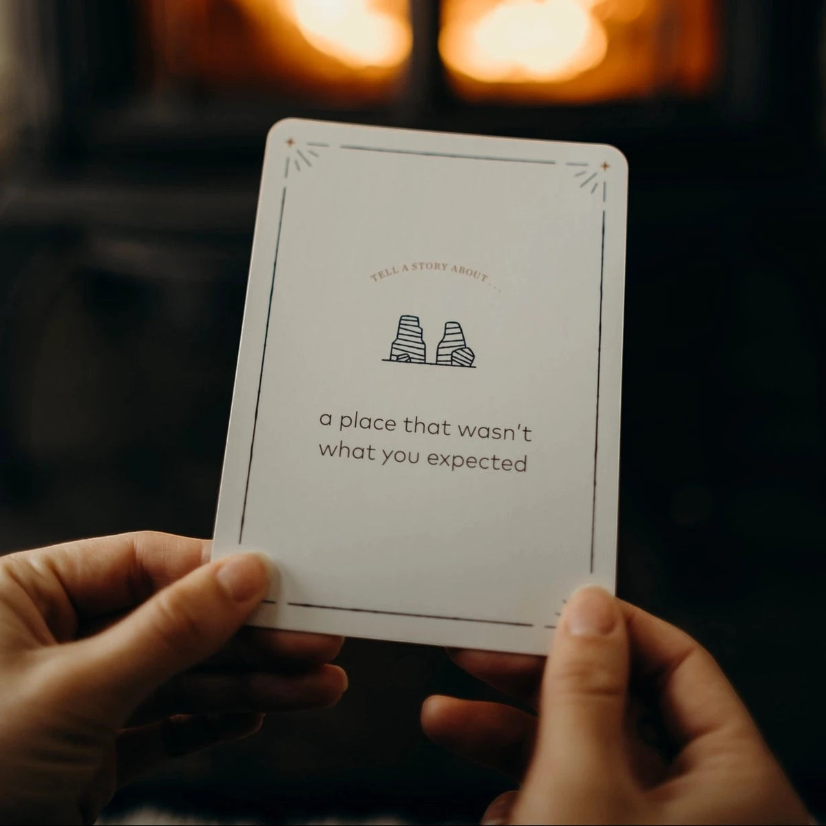 Forager Provisions LTD Campfire Stories question card with nature-inspired illustration held in front of a fireplace
