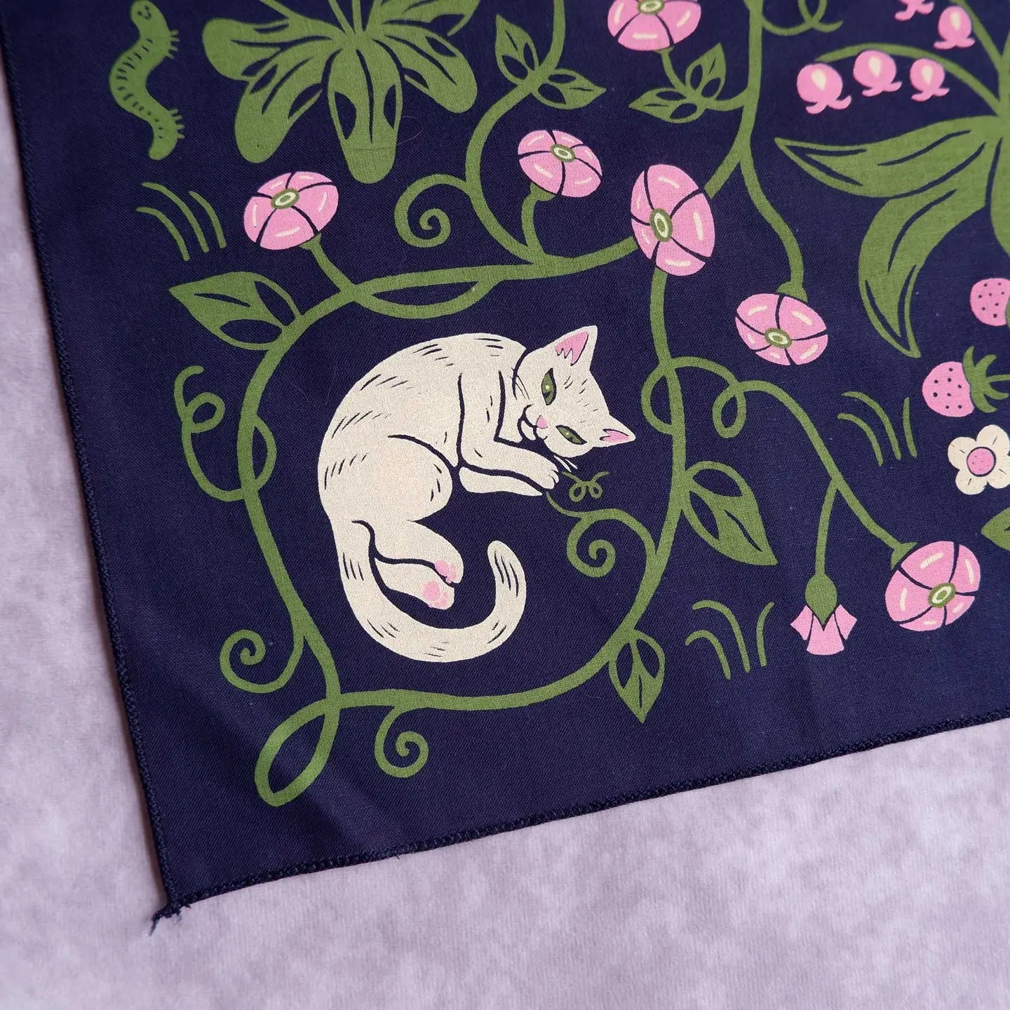 Forager Provisions LTD Cat Coven cotton bandana featuring a white cat among pink flowers and green vines on navy