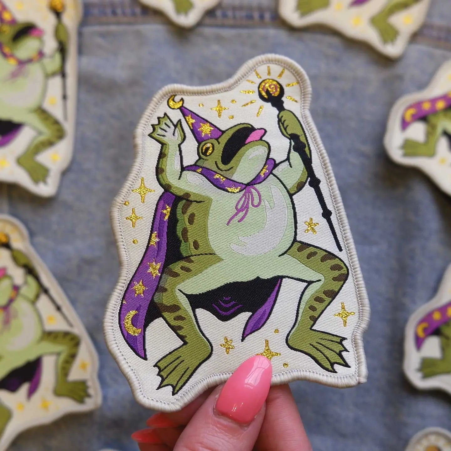 Forager Provisions LTD Cat Coven woven patch featuring a green toad wizard in a purple cape holding a staff.