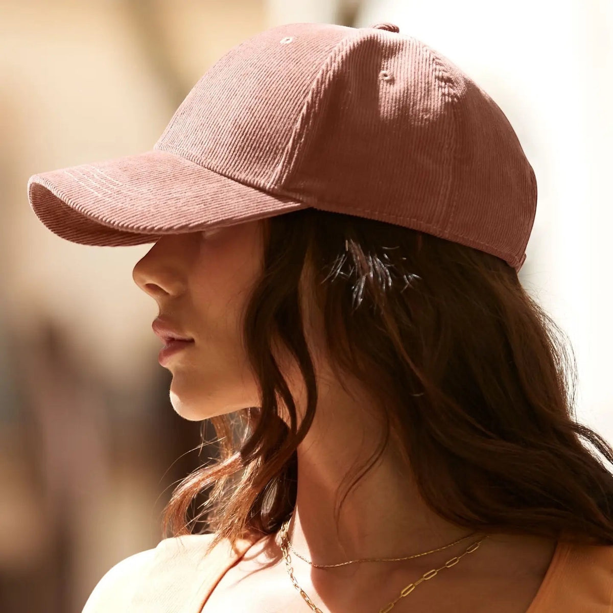 Side view of a person with long hair in a Redwood Forager Provisions Earthaware® Cord Baseball Cap stylish eco headwear.