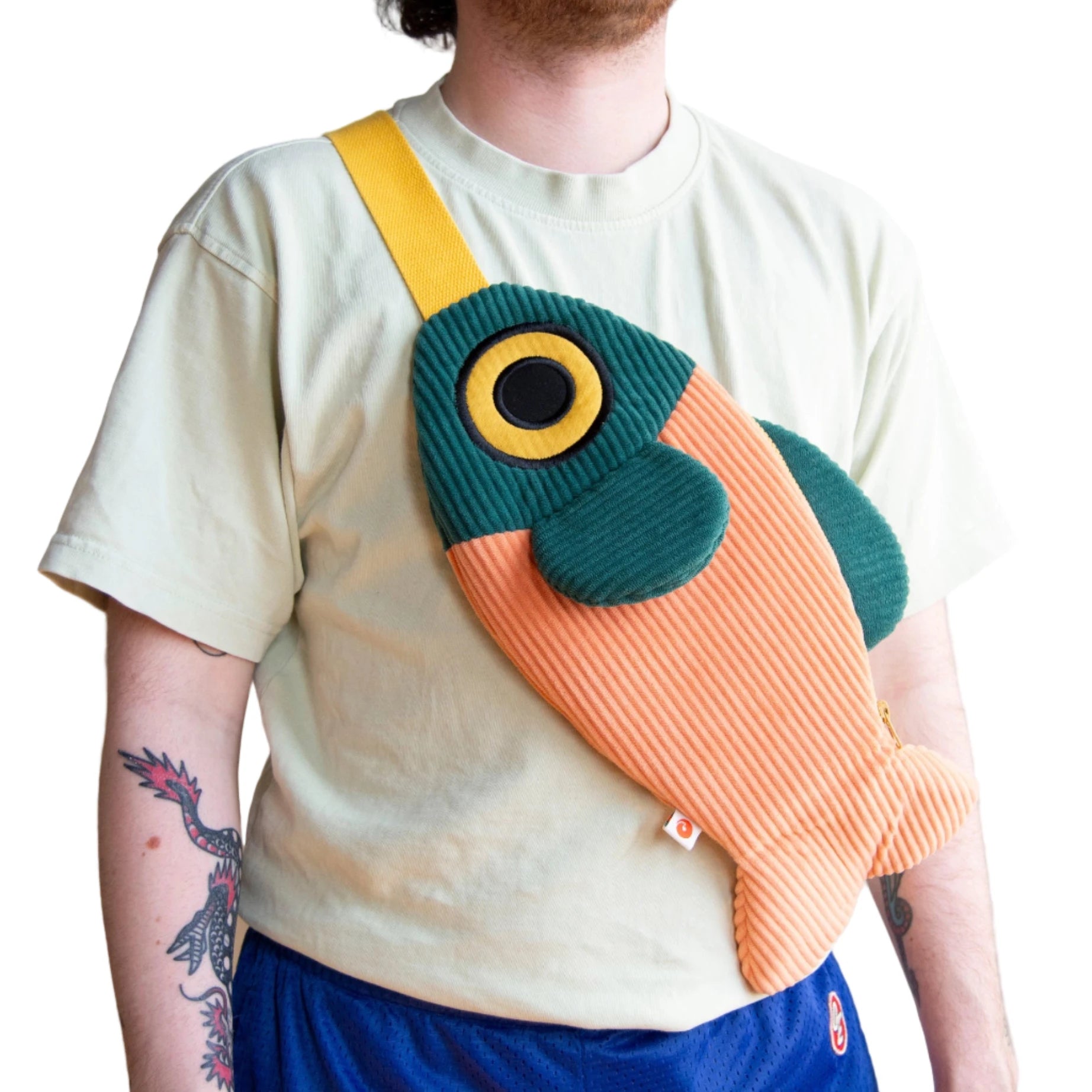 Individual with Curlworks The Fish Bag in coral salmon & dark green crossbody style, trending designer accessory for 2024 fashion.