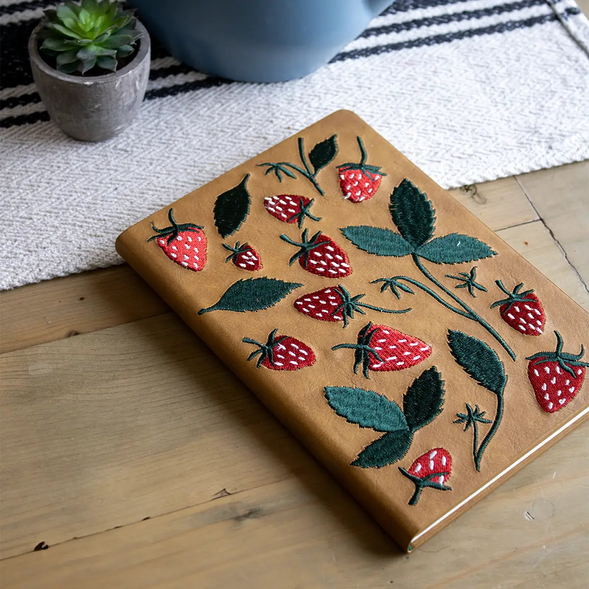 Forager Provisions LTD Denik journal with tan cover featuring raised red strawberry and green leaf embroidery