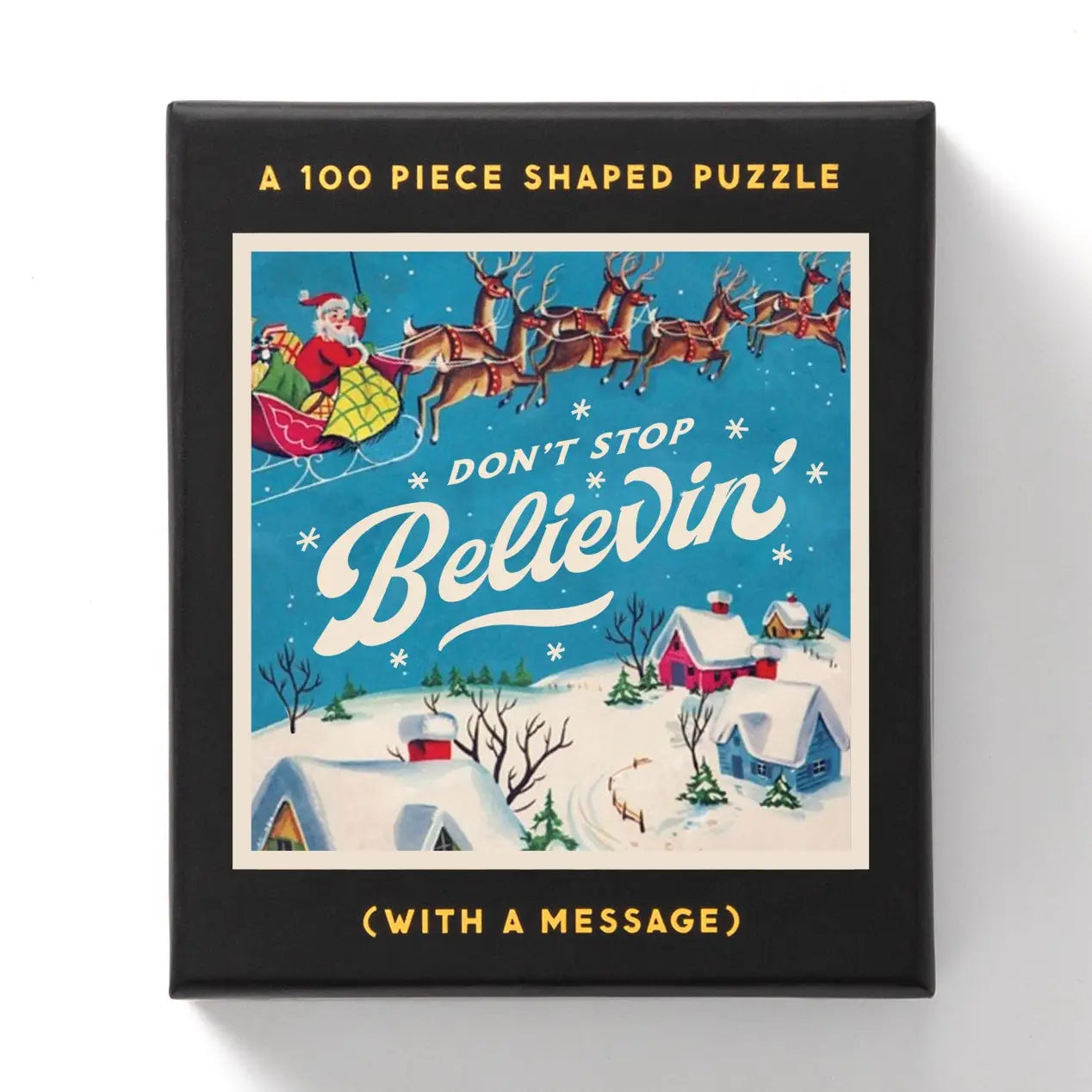 Brass Monkey Don't Stop Believin' 100 Piece Mini Shaped Puzzle shows Santa and reindeer soaring above snowy houses at Christmas.