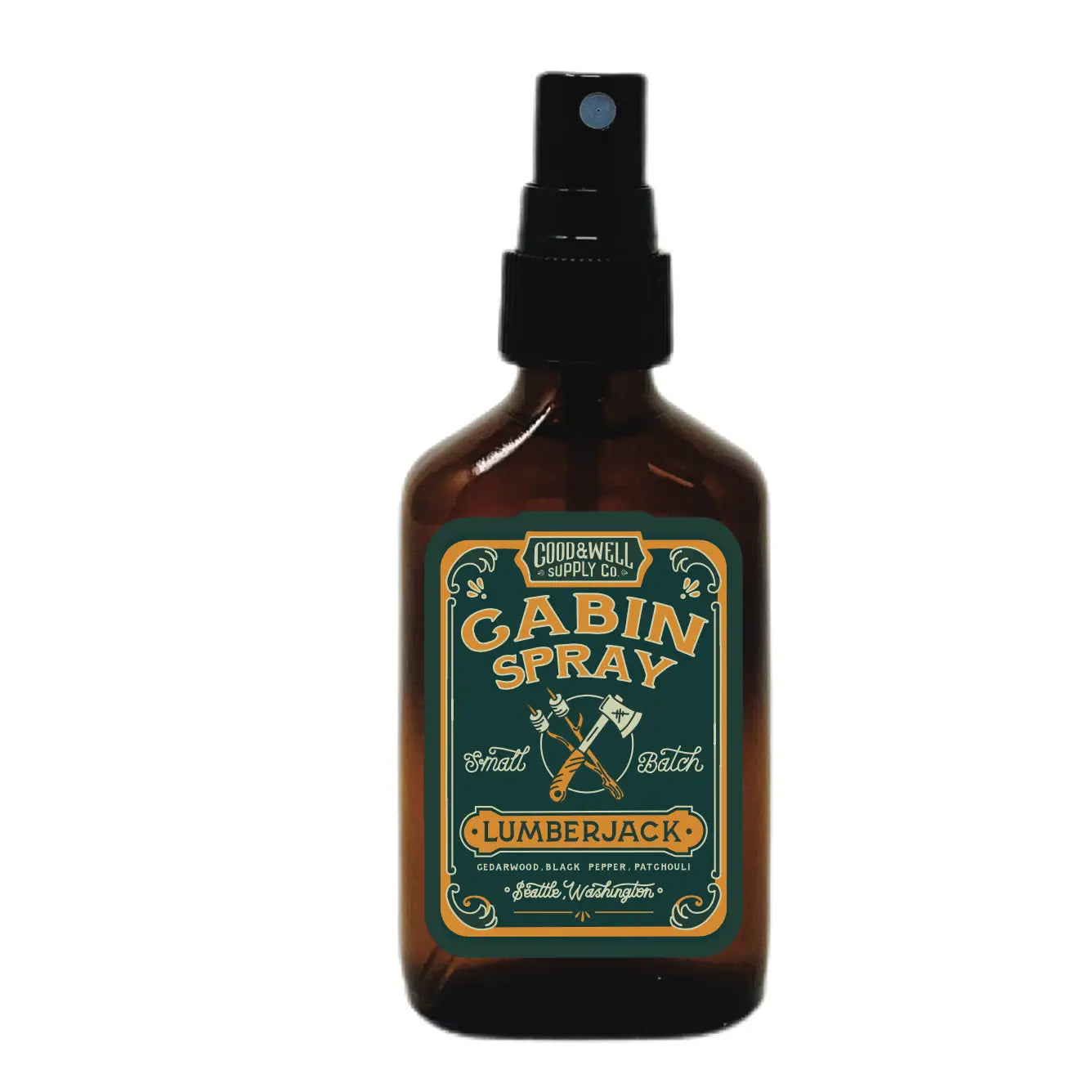 Introducing the Good & Well Supply Co Cabin Room Spray - Lumberjack, a dark amber bottle adorned with crossed axes and an ornate design in green and gold. This apothecary-style room spray is perfect for anyone seeking cedarwood-infused ambiance.